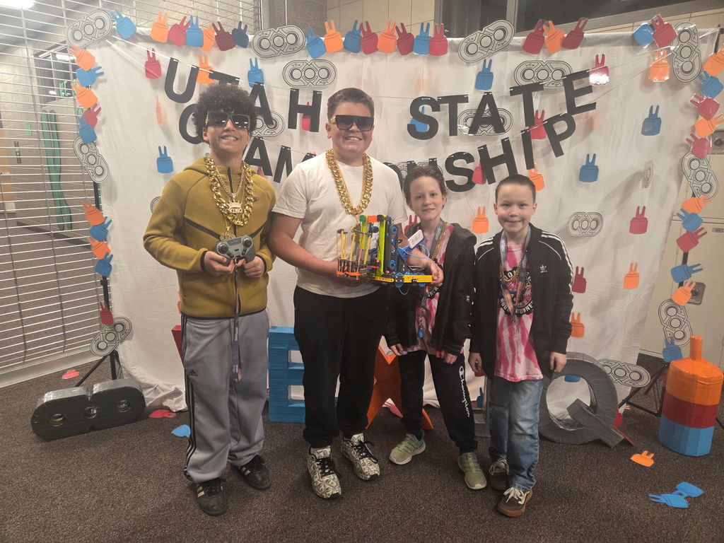 4 students posing with their robot at the state championship competition