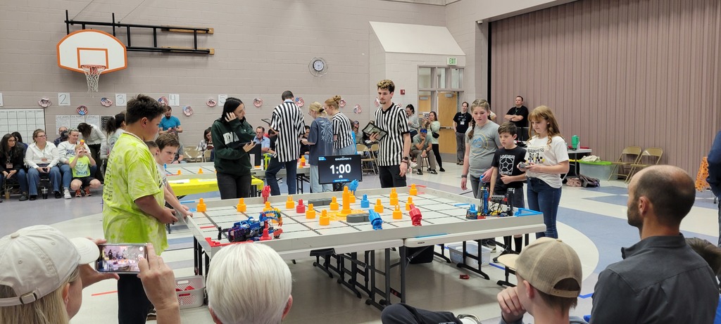 Two robotics teams competing at a robotics competition