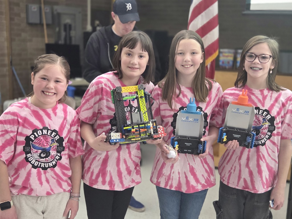 4 students posing with their robot and awards at a robotics competition