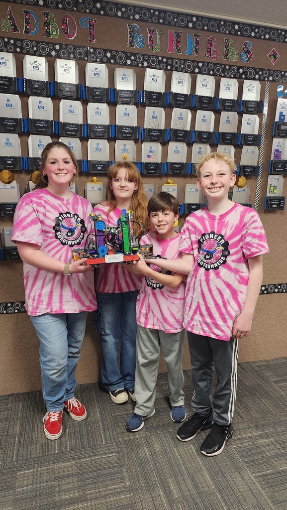 4 students posing with their robot 