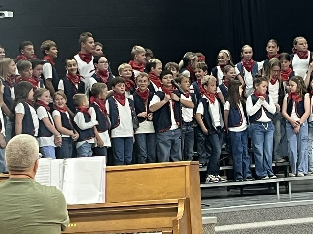 Students dressed as cowboys singing in a school choir.