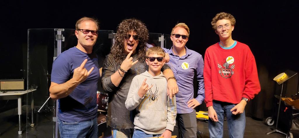 Group of five members of from a band giving the hand loose sign. 