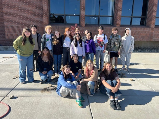 Students posing for picture in front of the school.
