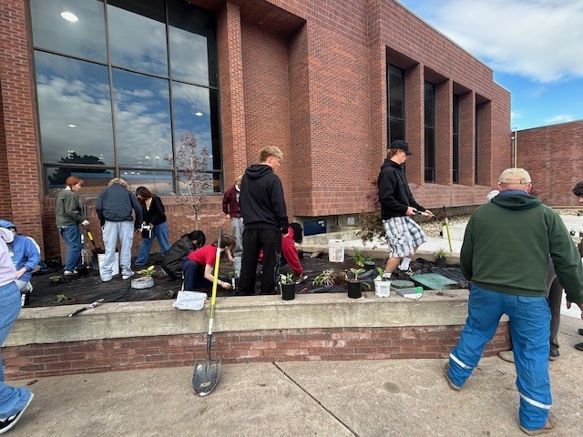 Students planting in the flower beds in front of Bonneville High School.