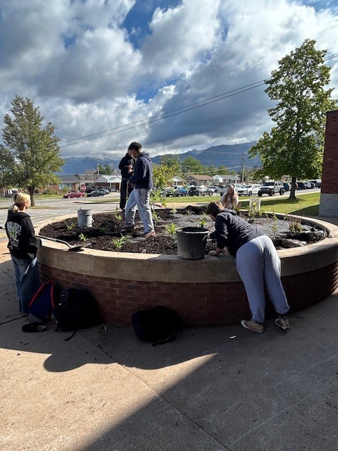 Students planting in the flower beds.