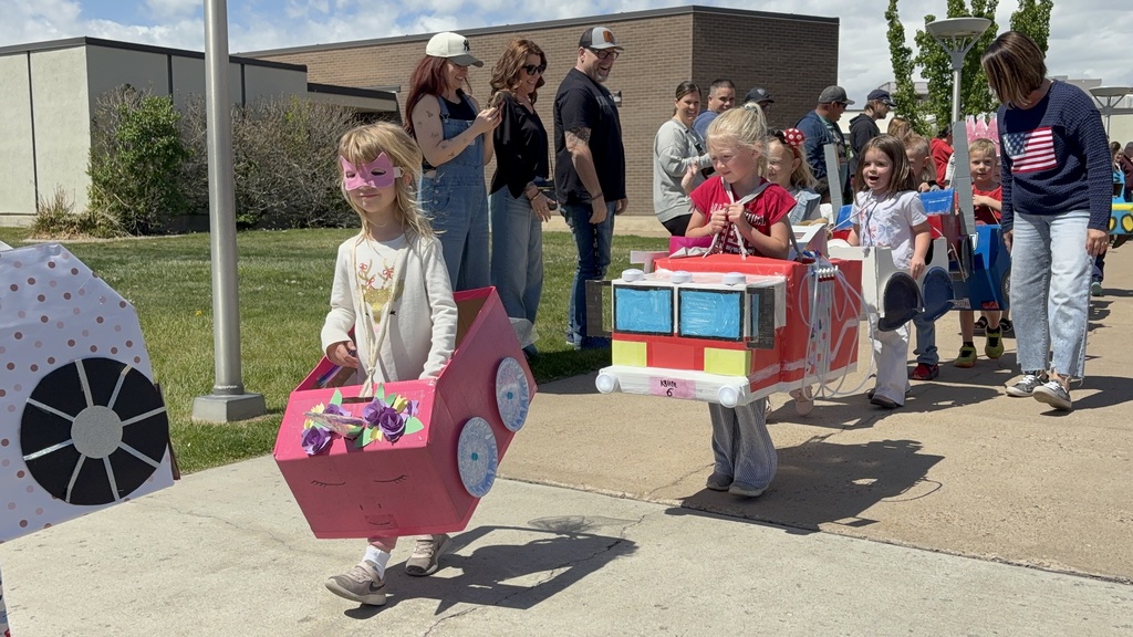 KIndergarteners driving their homemade cars at kindy 500 parade
