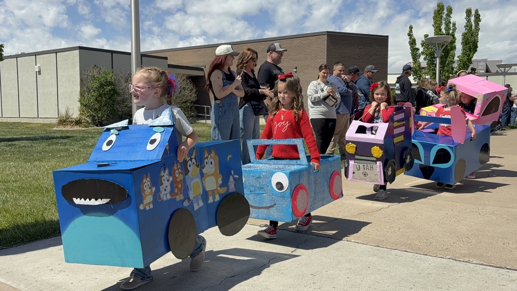 KIndergarteners driving their homemade cars at kindy 500 parade