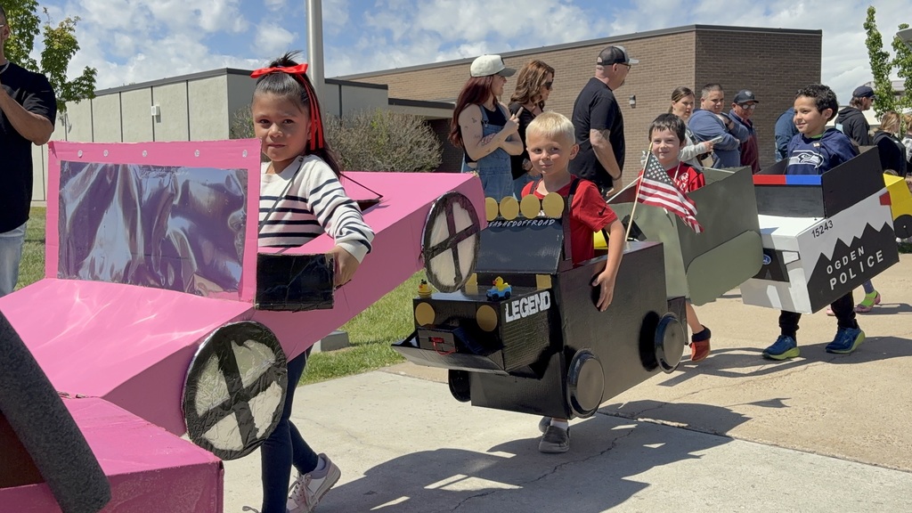 KIndergarteners driving their homemade cars at kindy 500 parade
