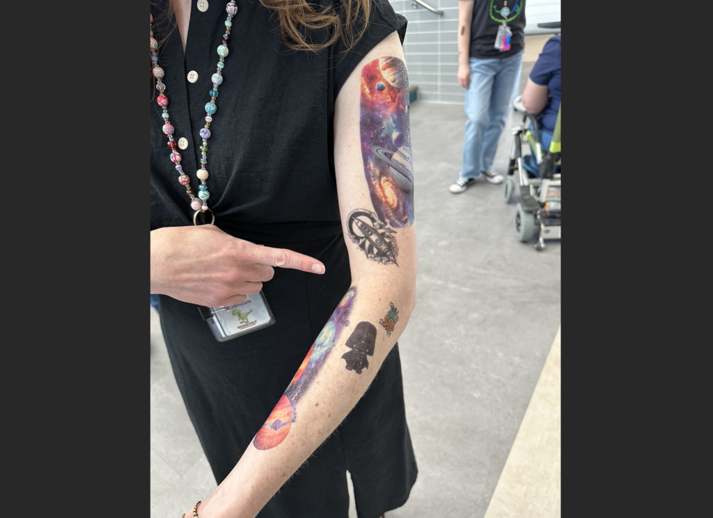 a teachers arm all covered in tattoos