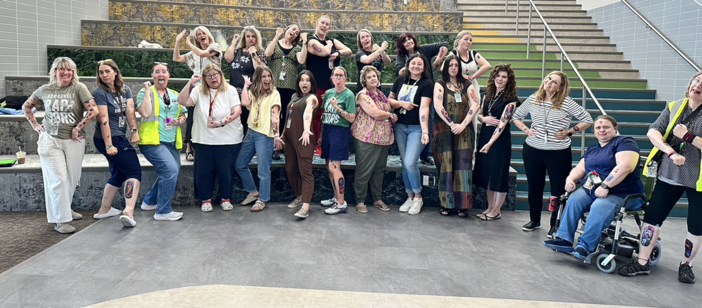 Roosevelt Staff posing with silly faces and showing off all their tattoos