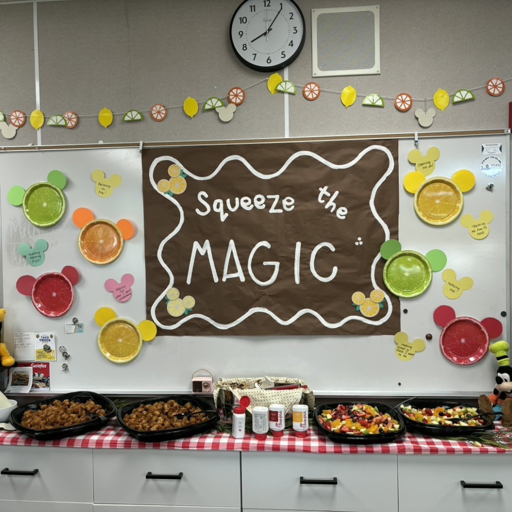food table with a poster that says Squeeze the Magic 