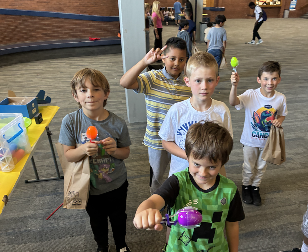 2nd grade boys holding treats that they got from a pinata