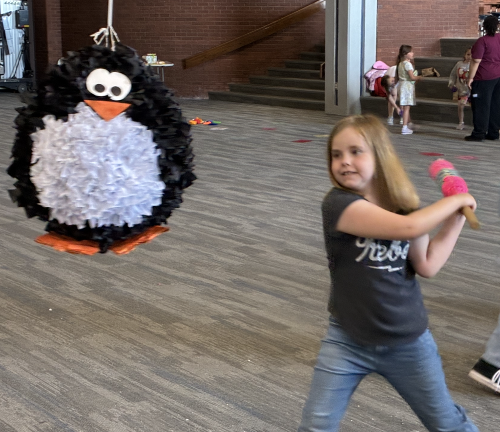 a student getting ready to hit a pinata
