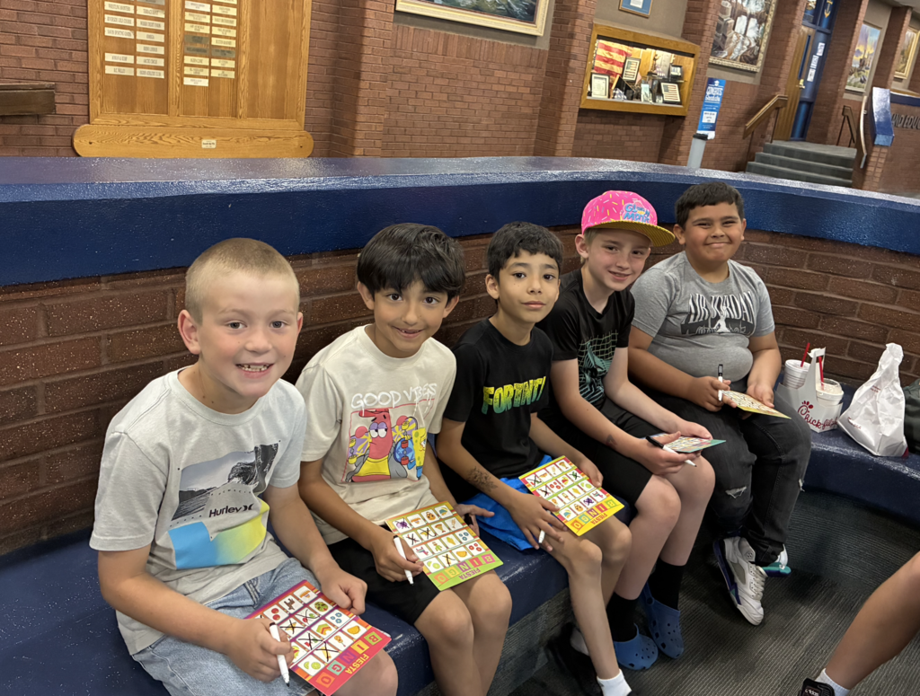A group of 2nd grade boys smiling and playing bingo