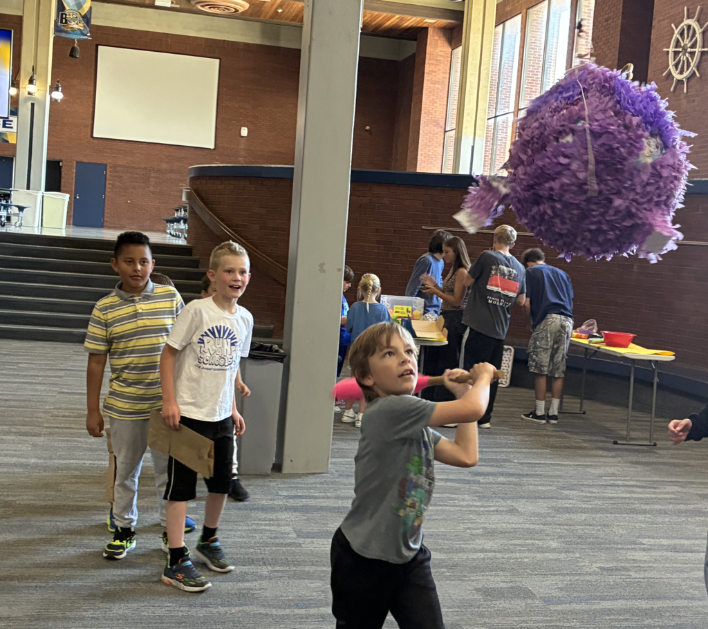 a student getting ready to hit a pinata