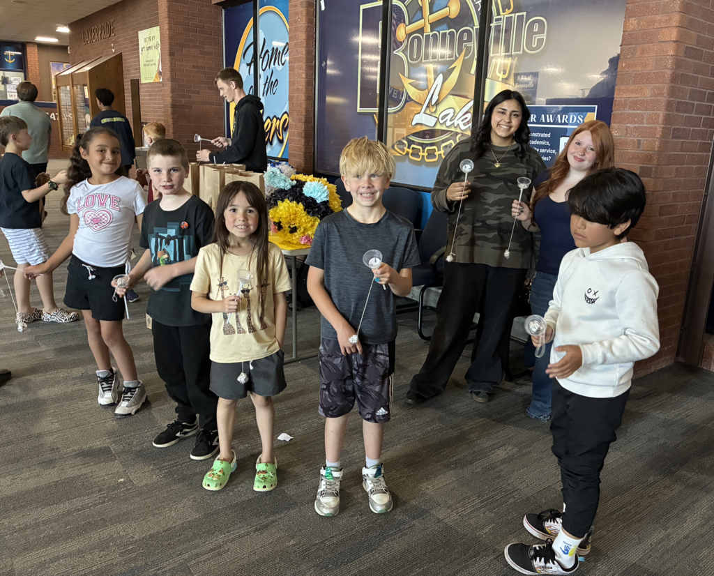 second graders and high school students playing with boleros