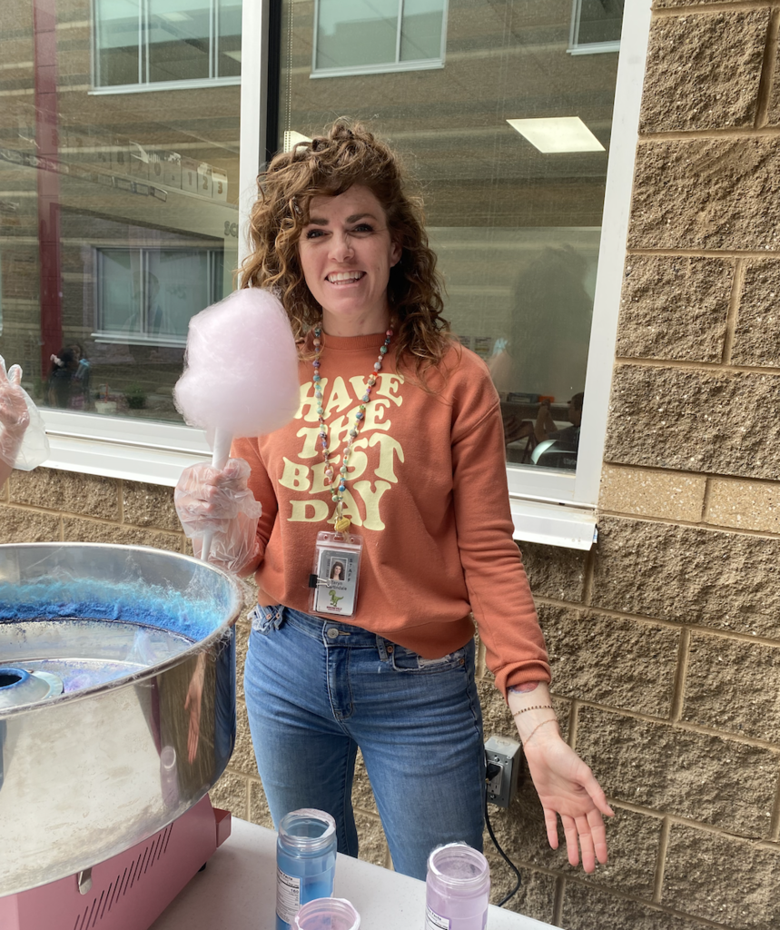 Ms. Martindale holding a stick of pink cotton candy
