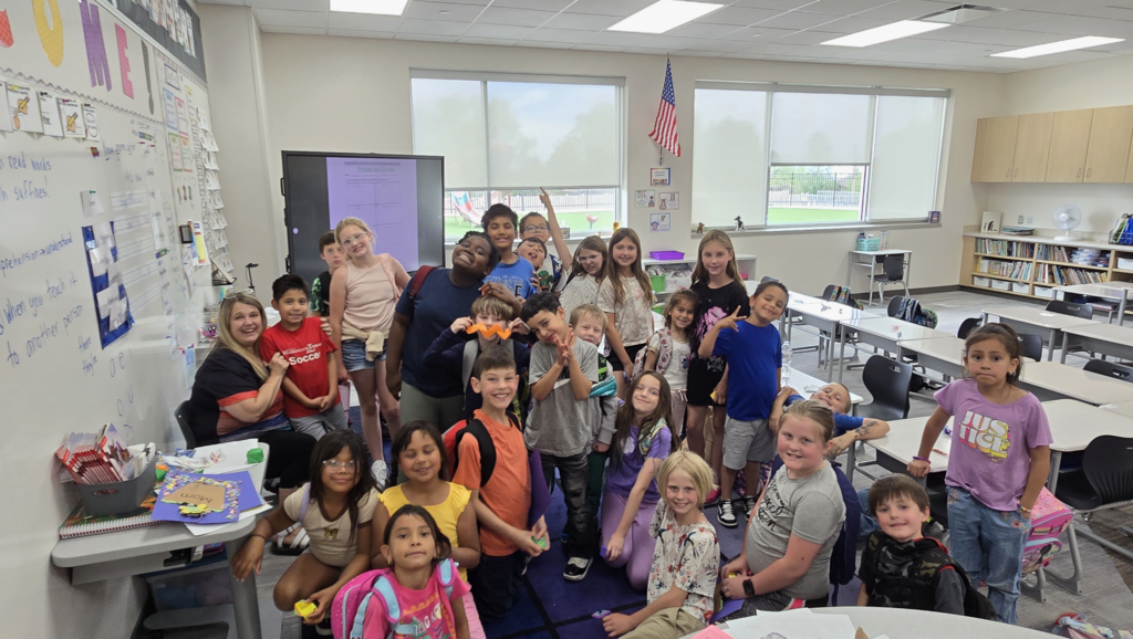 a group of 4th grade and 1st grade students posing together as a group for a picture