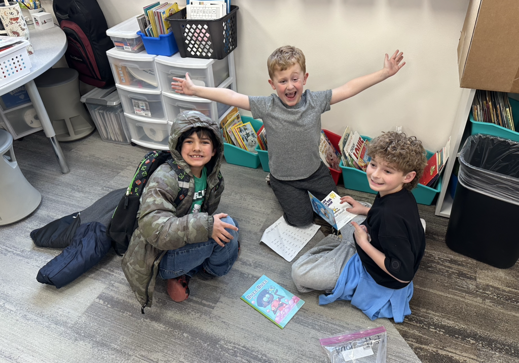 two first graders and a 4th grader reading together