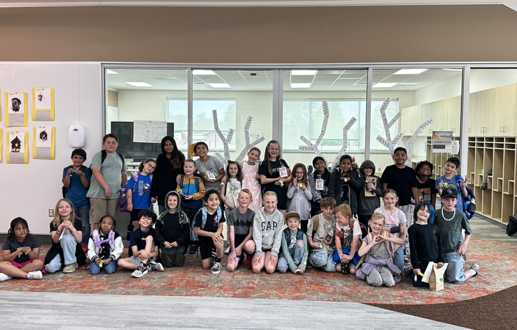 a group of 4th grade and 1st grade students posing together as a group for a picture