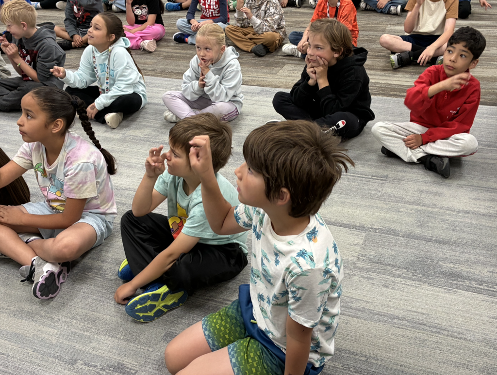2nd grade students using sign language so that they don't scare the animals from the rainforest
