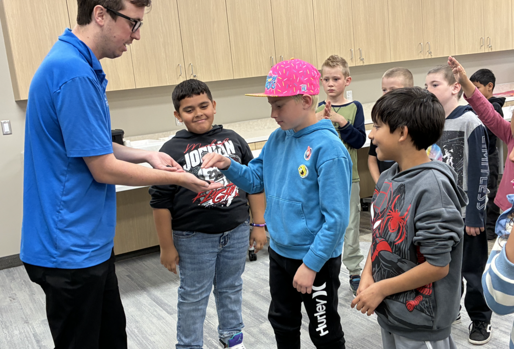 student getting ready to pet a centipede
