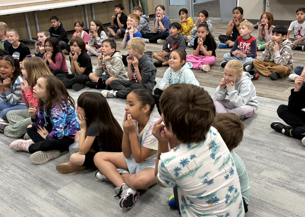 2nd grade students using sign language so that they don't scare the animals from the rainforest