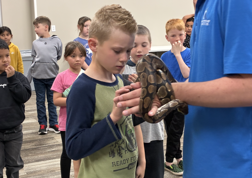 a student petting a snake