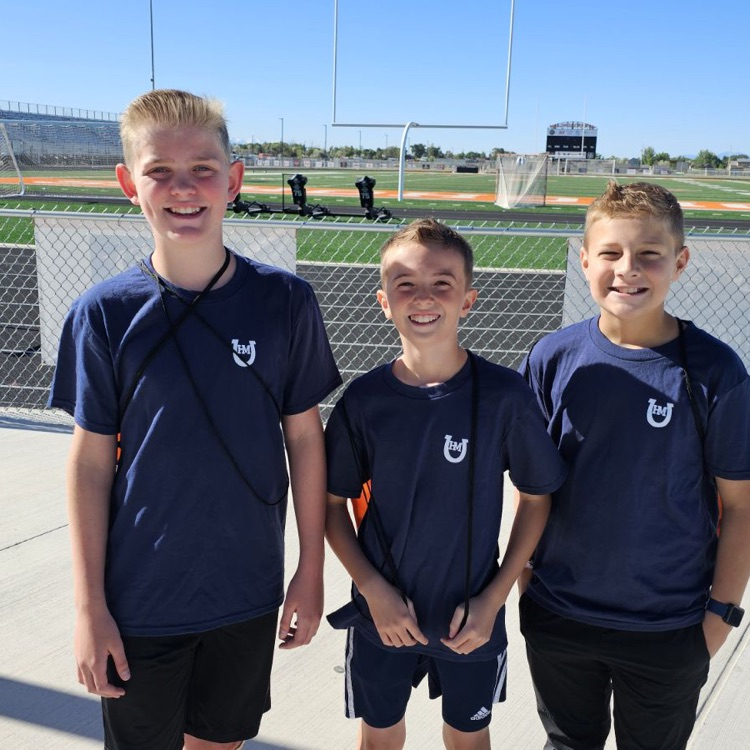 three boys wearing blue shirts