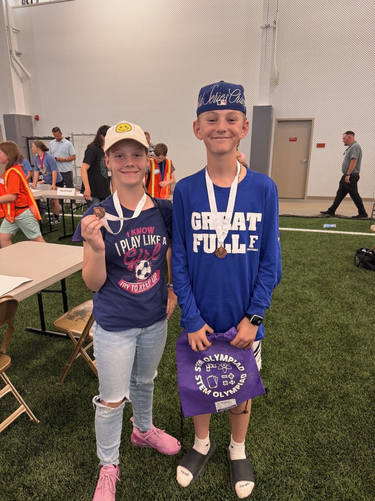 two students smiling with awards