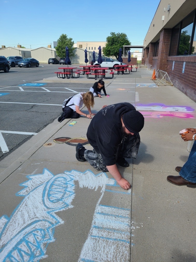 students work on sidewalk drawings