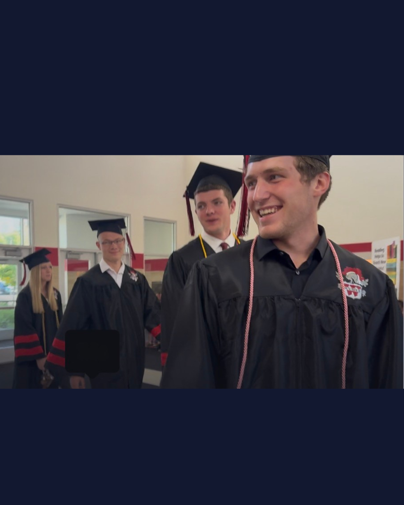 Gaduates entering OSE in cap and gown 