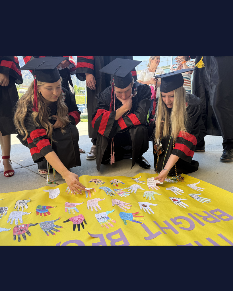 Graduates looking at a poster they created when they were in 6th grade. 