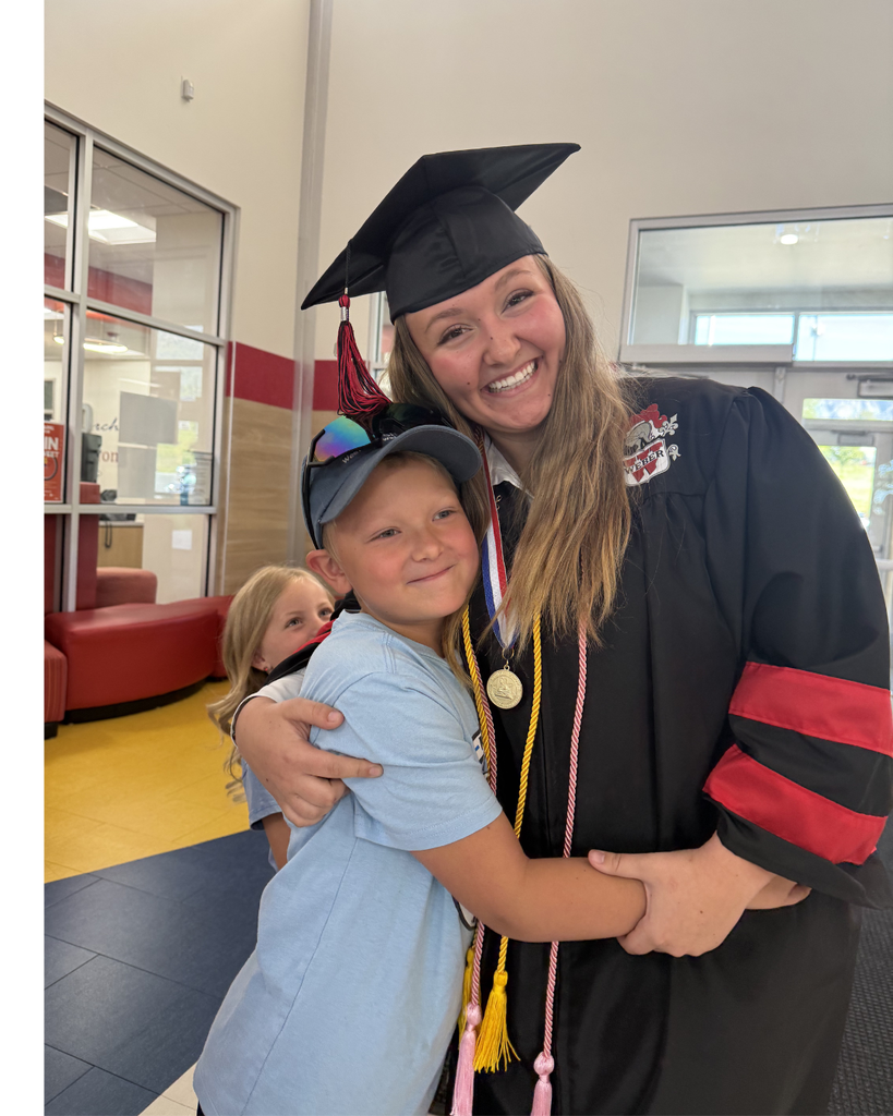 Graduate hugging a sibling 