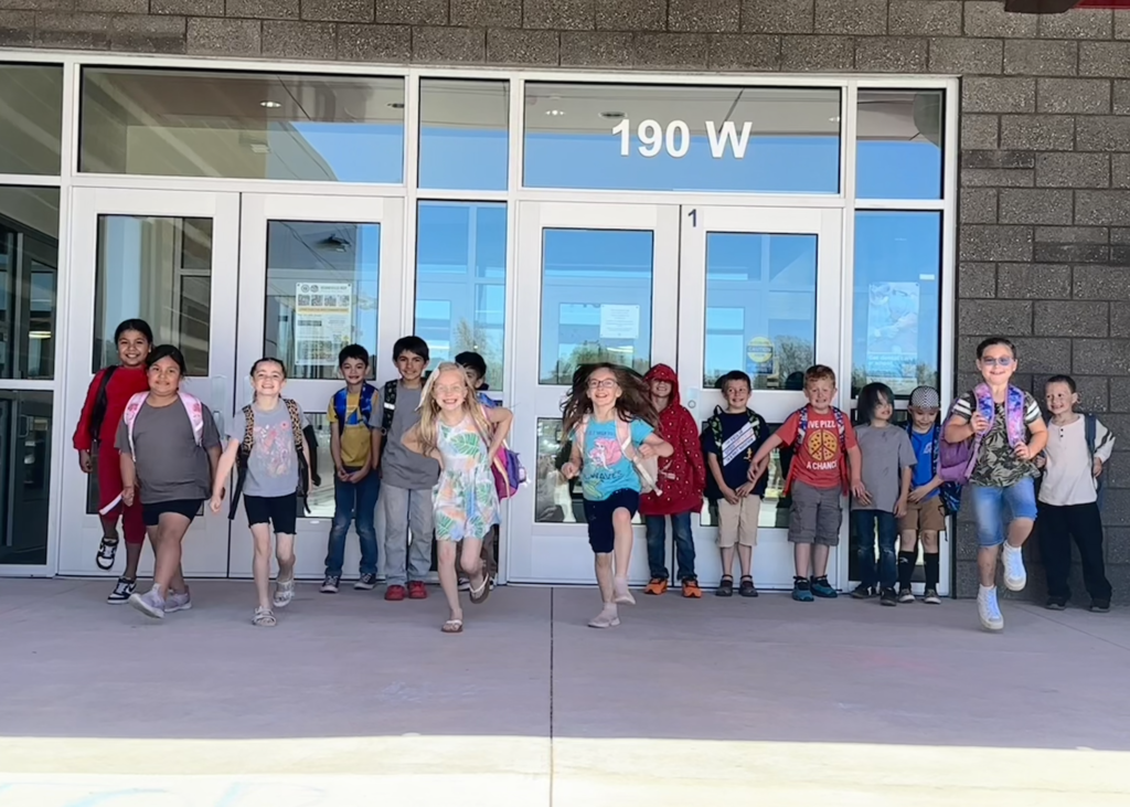 a group of students leaving the school building with happy looks on their faces