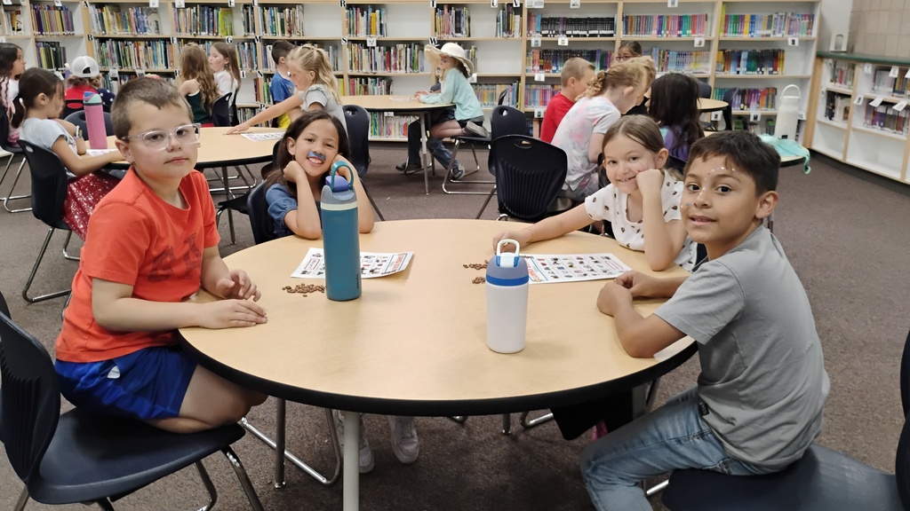Students smiling playing Bingo on Field Day, with cute face paint