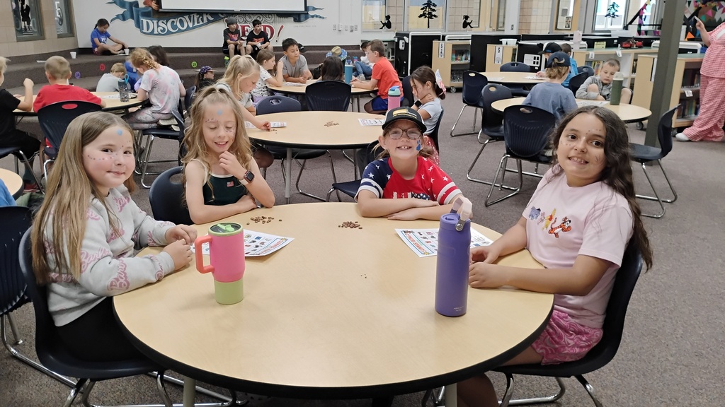 Students smiling playing Bingo on Field Day, with cute face paint