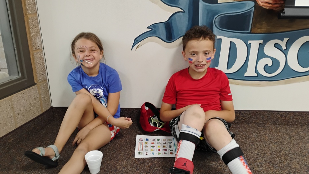 Students smiling playing Bingo on Field Day, with cute face paint