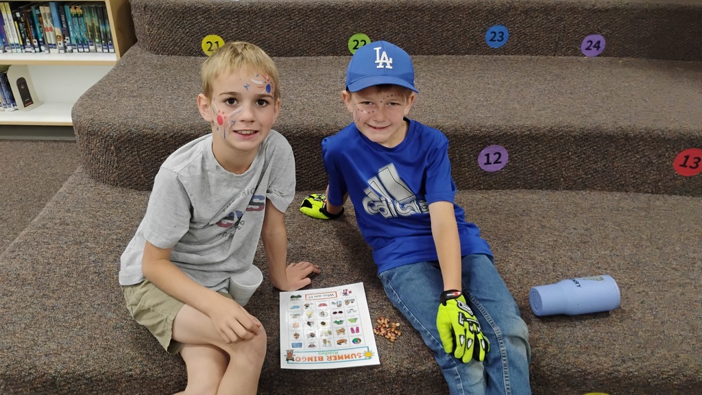 Students smiling playing Bingo on Field Day, with cute face paint