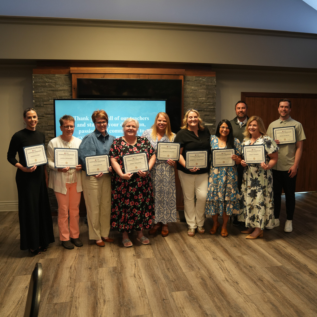All award winners holding up their award certificates.