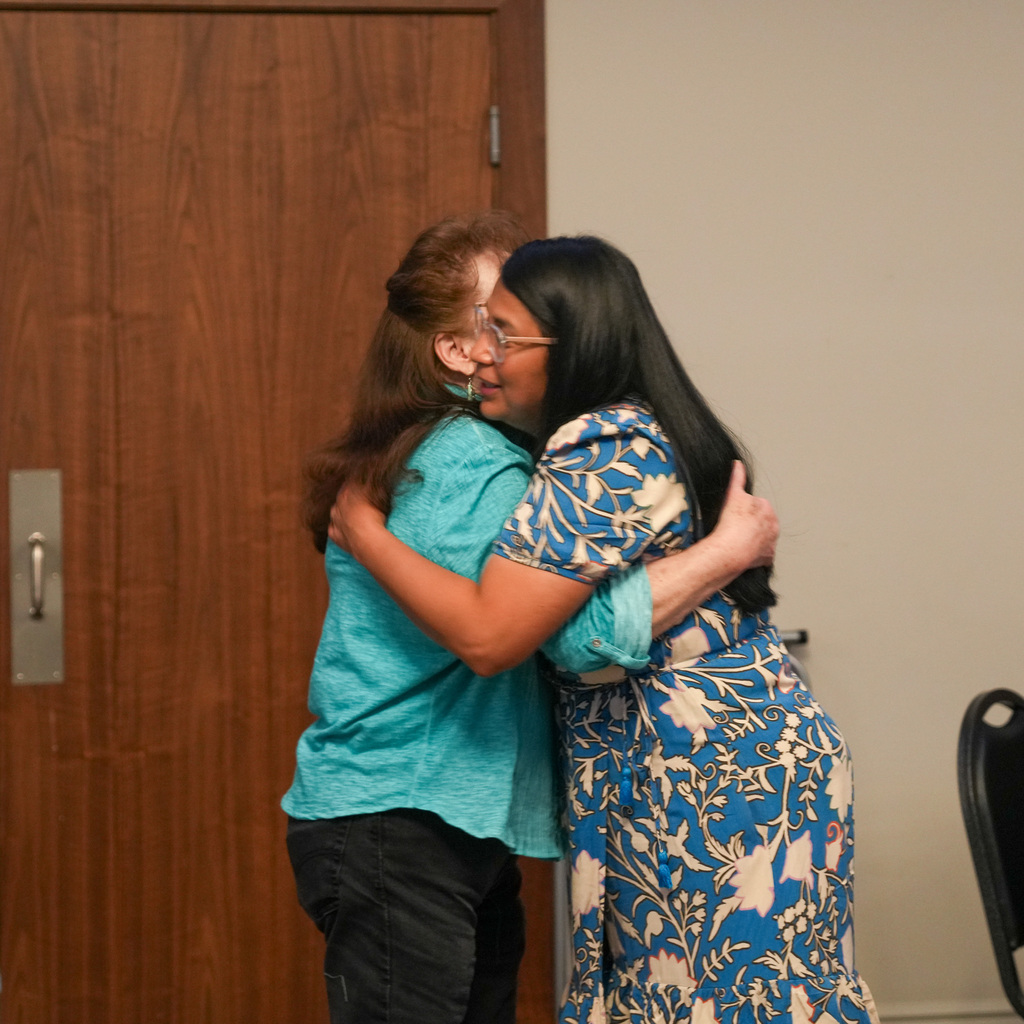 Two awardees in an embrace