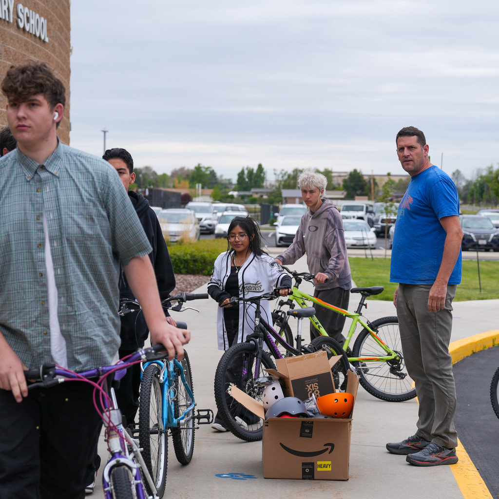 High students unloading bicycles in front of the school