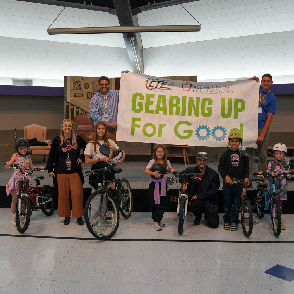 Students standing next to the bikes with a sign held behind them with gearing up for good