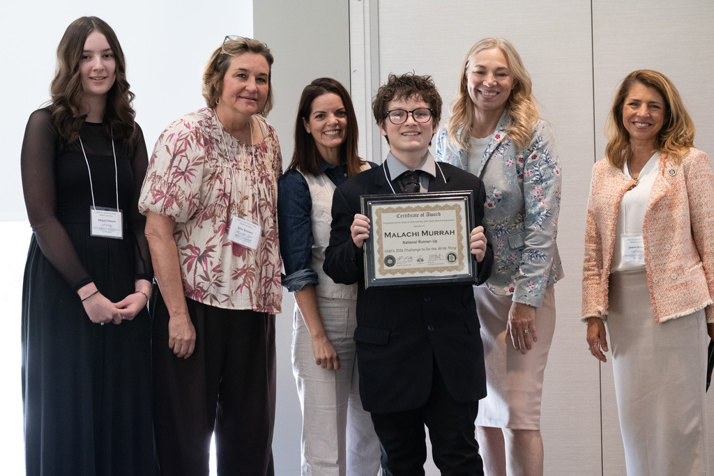 Malachi holding the award with supporters