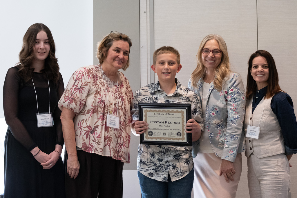 Tristan holding the award with supporters