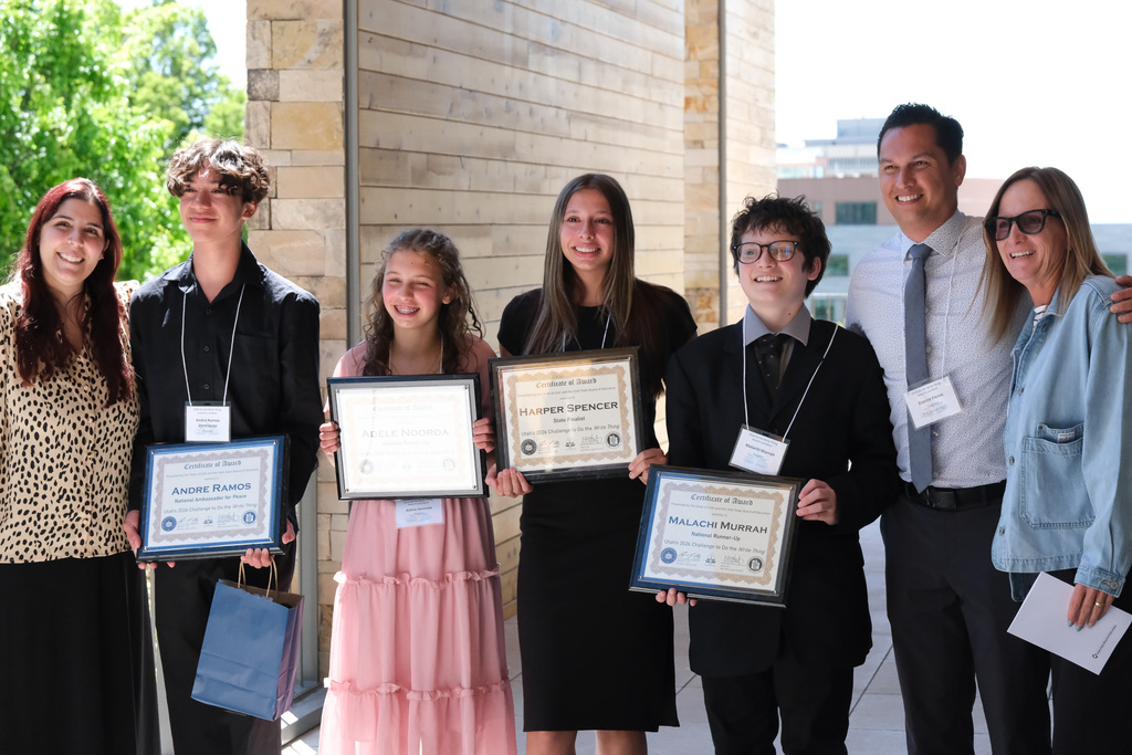 A group of students holding their awards with teachers and administrator