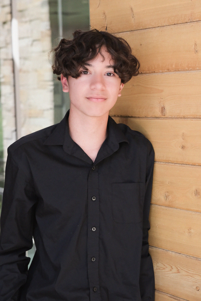 Andre standing next to wood texture wall