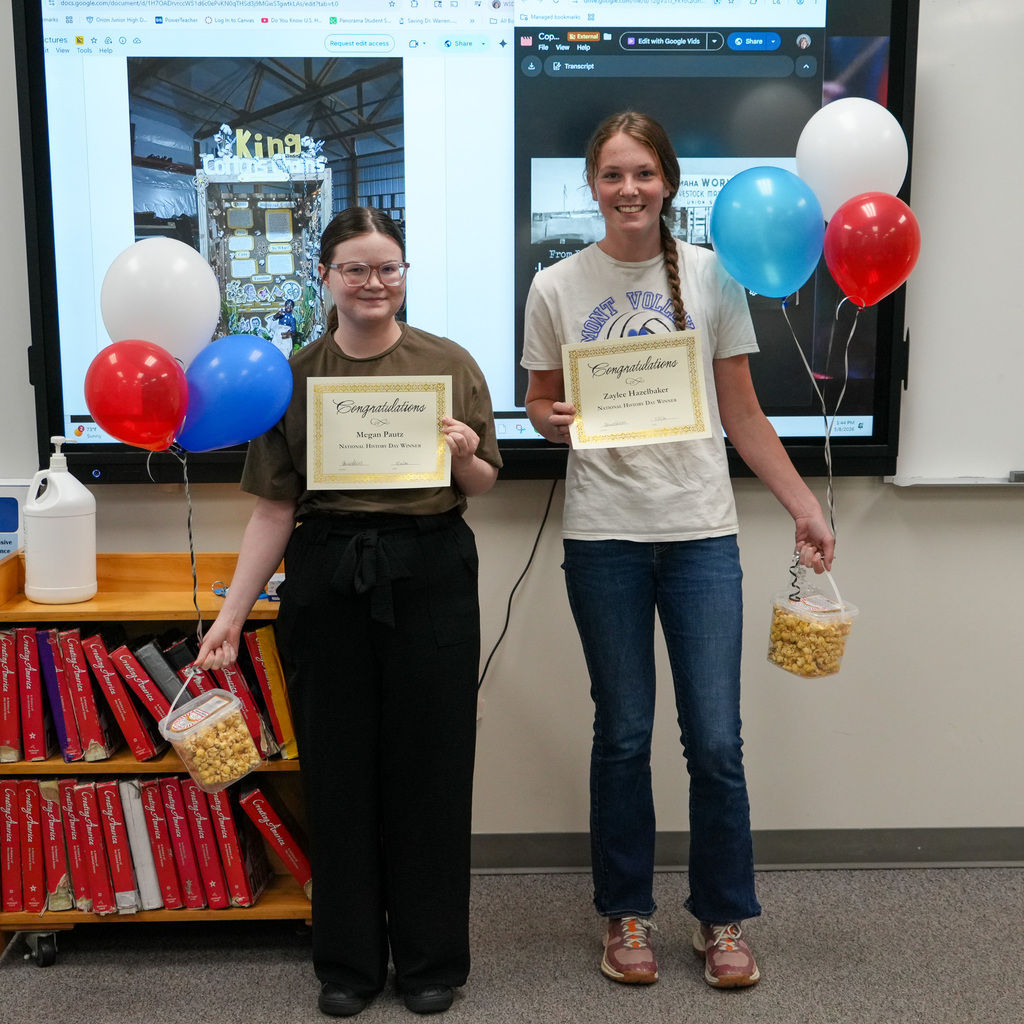 Two students pose with their award certificates