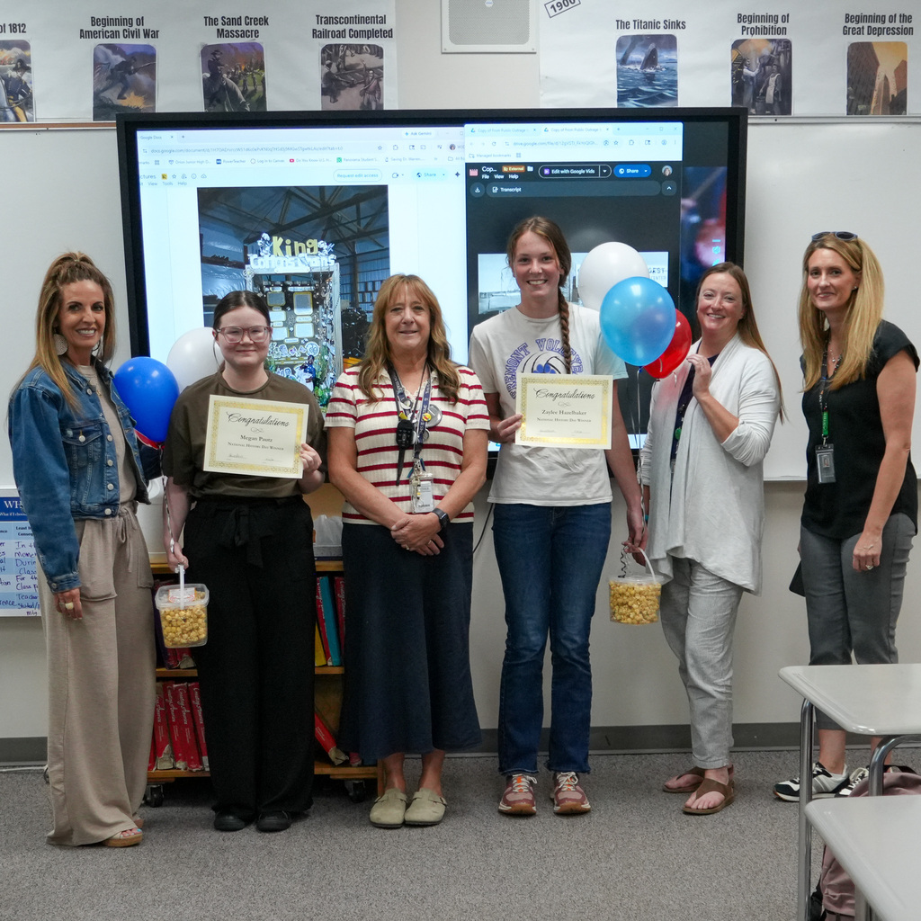 Two students pose with their award certificates along with their teacher and district leaders
