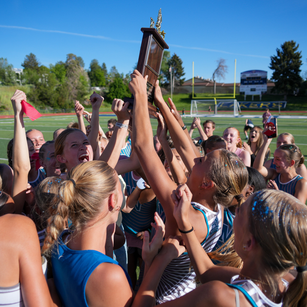 A group of Mountain view girls hold the trophy in a crowd